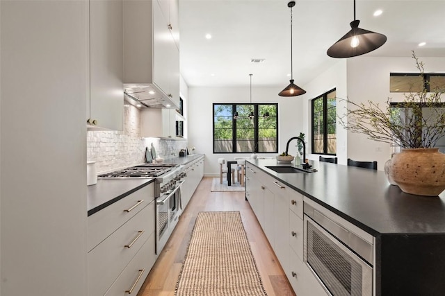 5218 Valley Oak Dr, Austin, TX 78731 - kitchen with appliances with stainless steel finishes, dark countertops, backsplash, white cabinets, and recessed lighting