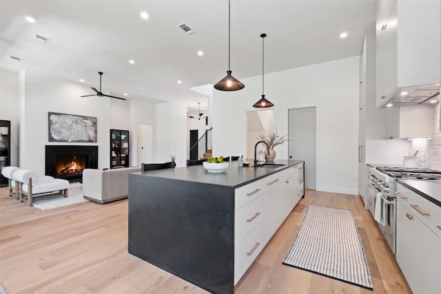 5218 Valley Oak Dr, Austin, TX 78731 - kitchen with range with two ovens, premium range hood, a ceiling fan, white cabinetry, and dark countertops