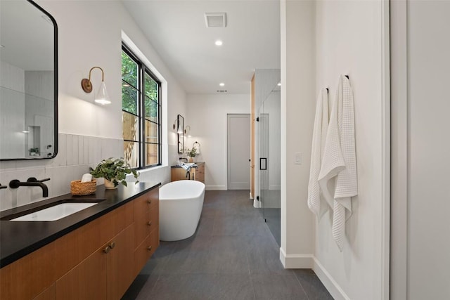 5218 Valley Oak Dr, Austin, TX 78731 - full bathroom featuring vanity, a freestanding tub, a shower stall, and recessed lighting
