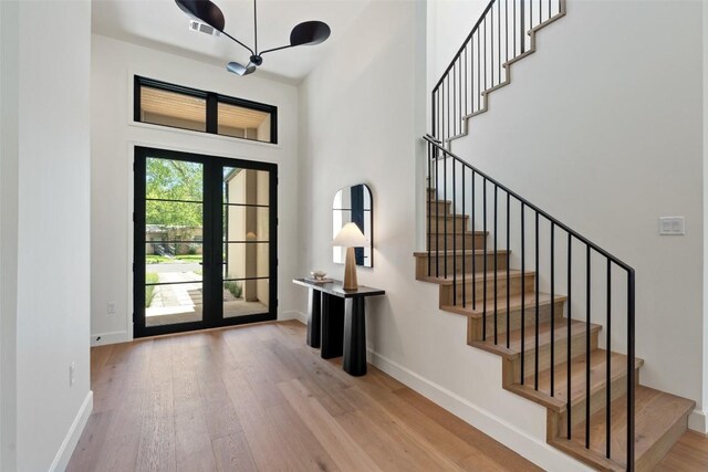 5218 Valley Oak Dr, Austin, TX 78731 - entryway with wood finished floors, stairs, a chandelier, and a towering ceiling