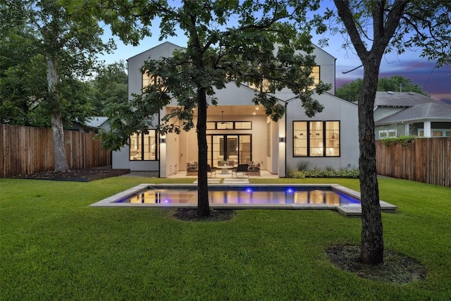 5218 Valley Oak Dr, Austin, TX 78731 - back of house at dusk featuring stucco siding, a fenced backyard, french doors, and a patio area