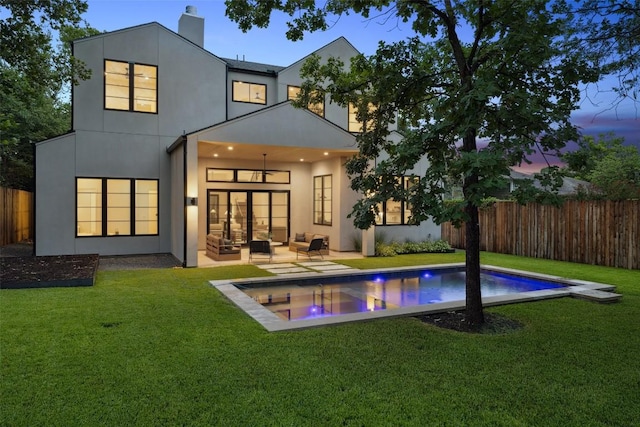 5218 Valley Oak Dr, Austin, TX 78731 - back of property at dusk featuring french doors, a fenced backyard, a chimney, an outdoor living space, and a patio area