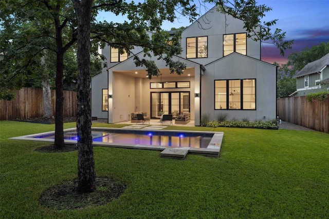 5218 Valley Oak Dr, Austin, TX 78731 - back of house at dusk with an outdoor hangout area, stucco siding, a fenced backyard, and a patio