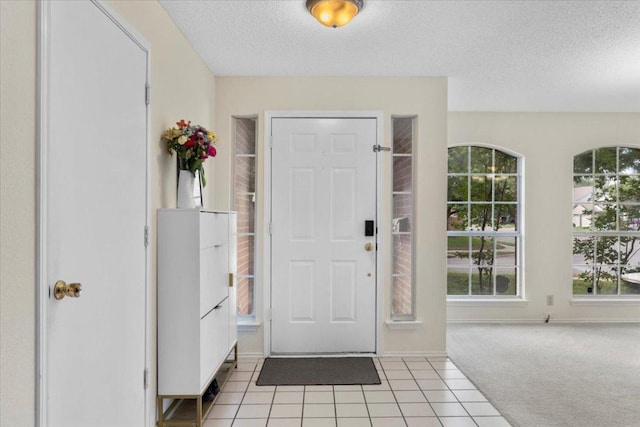 601 Wagon Wheel Trl, Pflugerville, TX 78660 - foyer with a textured ceiling, healthy amount of natural light, light carpet, and light tile patterned floors