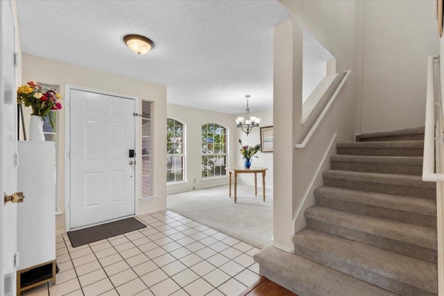 601 Wagon Wheel Trl, Pflugerville, TX 78660 - entrance foyer featuring stairs, a chandelier, light colored carpet, light tile patterned floors, and a textured ceiling