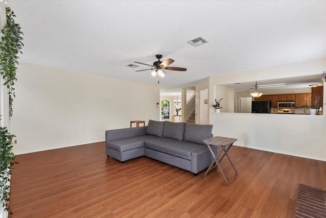 601 Wagon Wheel Trl, Pflugerville, TX 78660 - living area with light wood finished floors, stairway, a ceiling fan, and a textured ceiling