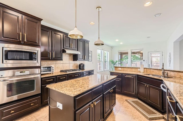4349 Green Tree Dr, Round Rock, TX 78665 - kitchen with appliances with stainless steel finishes, a sink, recessed lighting, decorative backsplash, and light stone countertops