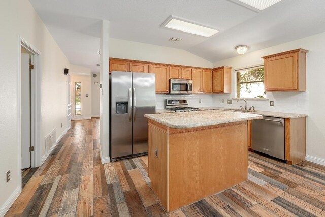 700 Horizon Trl, Cedar Park, TX 78613 - kitchen with appliances with stainless steel finishes, lofted ceiling, tasteful backsplash, a kitchen island, and wood finished floors