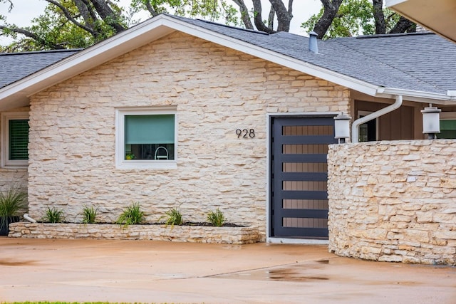 928 Porpoise St, Lakeway, TX 78734 - view of side of property with stone siding, roof with shingles, and an attached garage