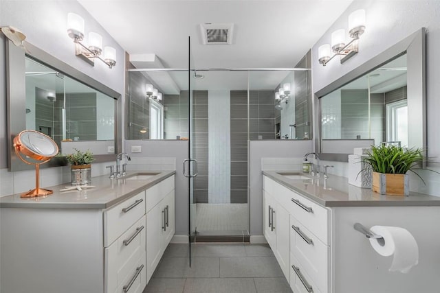 928 Porpoise St, Lakeway, TX 78734 - full bath with tile patterned flooring, two vanities, a shower stall, and baseboards