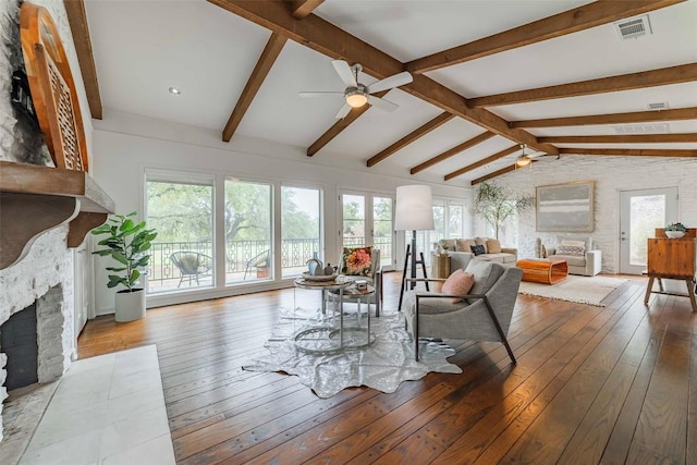 928 Porpoise St, Lakeway, TX 78734 - living room with a stone fireplace, a ceiling fan, hardwood / wood-style floors, and plenty of natural light