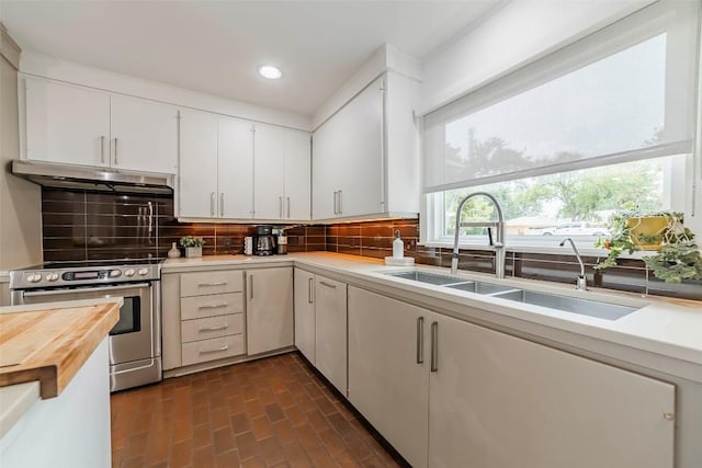 928 Porpoise St, Lakeway, TX 78734 - kitchen featuring under cabinet range hood, stainless steel range with electric stovetop, a sink, wood counters, and tasteful backsplash