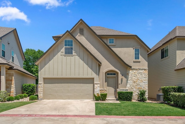 13501 Metric Blvd Unit 22, Austin, TX 78727 - view of front of property featuring board and batten siding, stone siding, concrete driveway, and a front lawn
