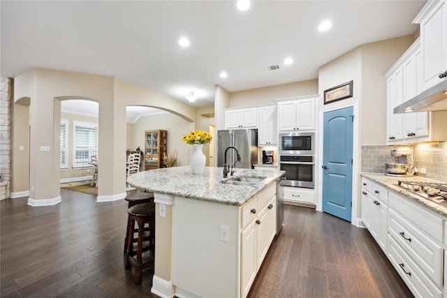 2628 Reunion Blvd, Austin, TX 78737 - kitchen featuring stainless steel appliances, a sink, arched walkways, a kitchen island with sink, and tasteful backsplash