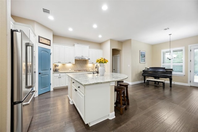 2628 Reunion Blvd, Austin, TX 78737 - kitchen with high end refrigerator, white cabinets, arched walkways, dark wood-style floors, and tasteful backsplash