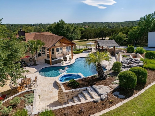 1020 Foothills Dr, Dripping Springs, TX 78620 - view of pool featuring a pool with connected hot tub, a patio area, and a wooded view