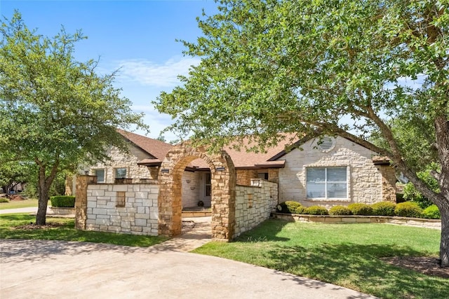 1020 Foothills Dr, Dripping Springs, TX 78620 - view of front of property featuring stone siding, a front lawn, and roof with shingles