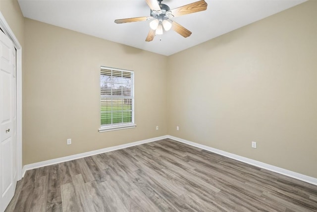 1301 S Quinlan Park Rd, Austin, TX 78732 - unfurnished bedroom featuring wood finished floors, a closet, baseboards, and a ceiling fan