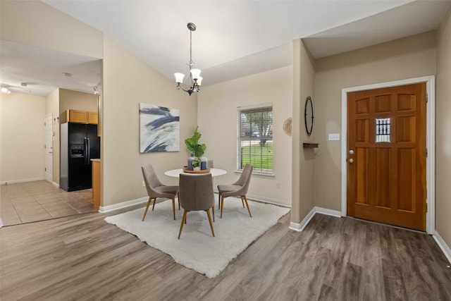 1301 S Quinlan Park Rd, Austin, TX 78732 - dining area featuring light wood-style flooring, a chandelier, and baseboards