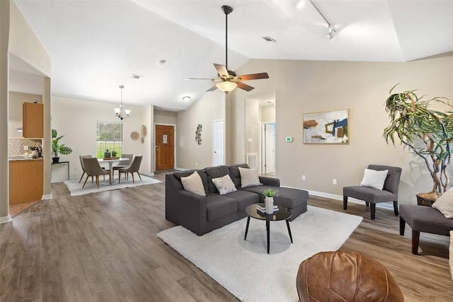 1301 S Quinlan Park Rd, Austin, TX 78732 - living area featuring wood finished floors, track lighting, vaulted ceiling, a chandelier, and a ceiling fan