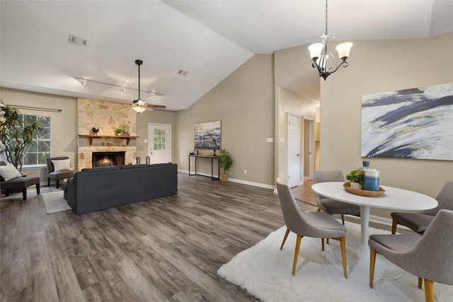 1301 S Quinlan Park Rd, Austin, TX 78732 - dining space with dark wood finished floors, a chandelier, a stone fireplace, a ceiling fan, and high vaulted ceiling