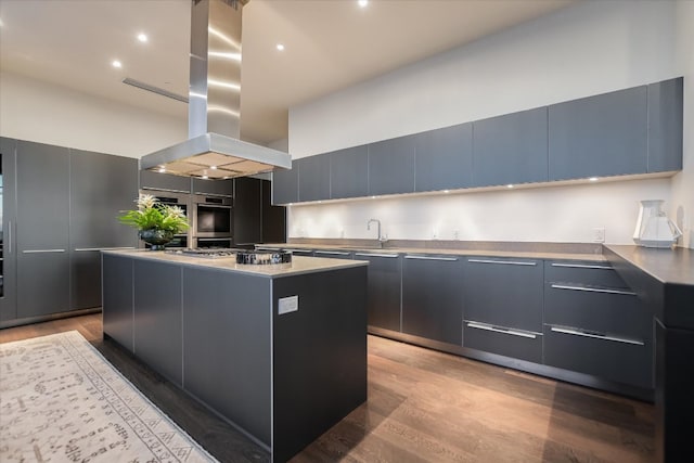 210 Lavaca St Unit 3603, Austin, TX 78701 - kitchen featuring modern cabinets, island exhaust hood, light wood finished floors, a kitchen island, and a towering ceiling