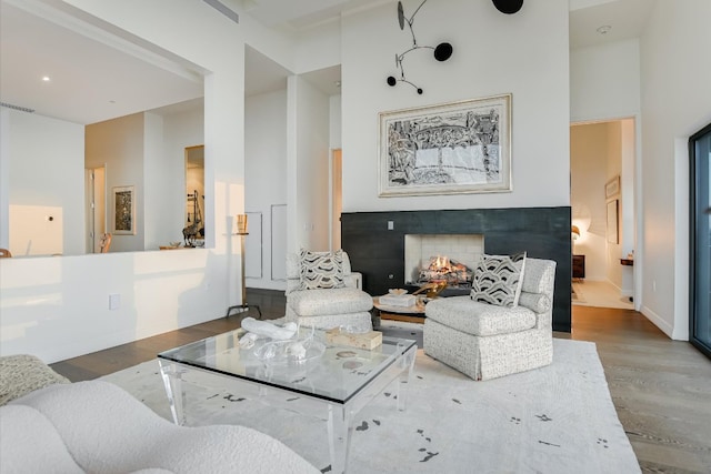 210 Lavaca St Unit 3603, Austin, TX 78701 - living room with a high ceiling, wood finished floors, a warm lit fireplace, and baseboards