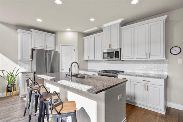 6500 Llano Stage Trl, Austin, TX 78738 - kitchen with stainless steel appliances, a sink, baseboards, an island with sink, and decorative backsplash