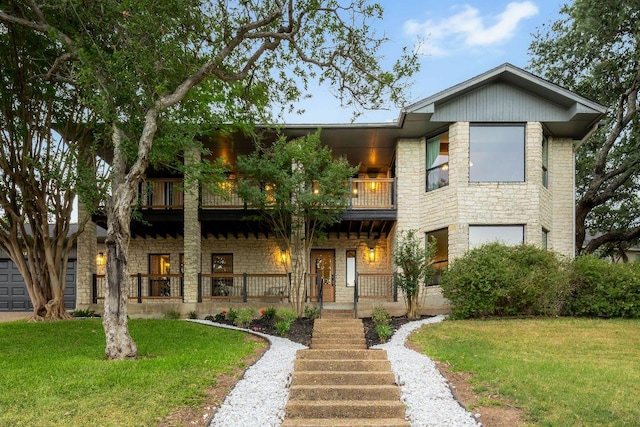 7302 Jester Blvd, Austin, TX 78750 - view of front of house with a balcony, stone siding, a front yard, and covered porch