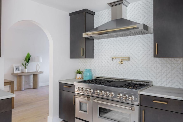7302 Jester Blvd, Austin, TX 78750 - kitchen with range with two ovens, wall chimney exhaust hood, arched walkways, and tasteful backsplash