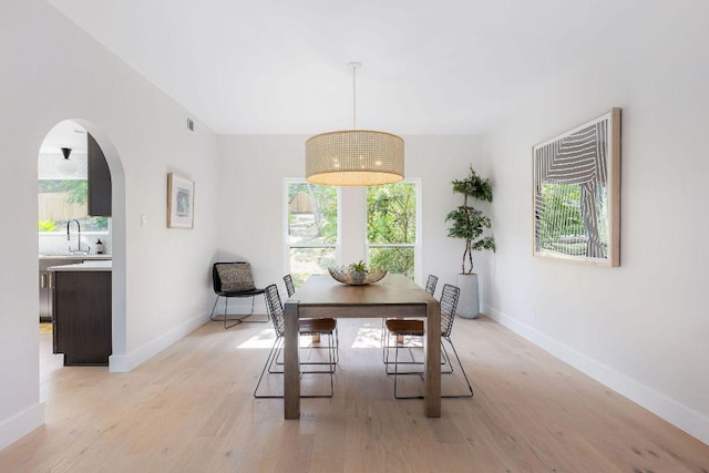 7302 Jester Blvd, Austin, TX 78750 - dining area featuring light wood-style floors, arched walkways, and baseboards