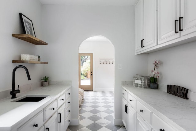 7302 Jester Blvd, Austin, TX 78750 - kitchen featuring a sink, open shelves, light floors, arched walkways, and white cabinets