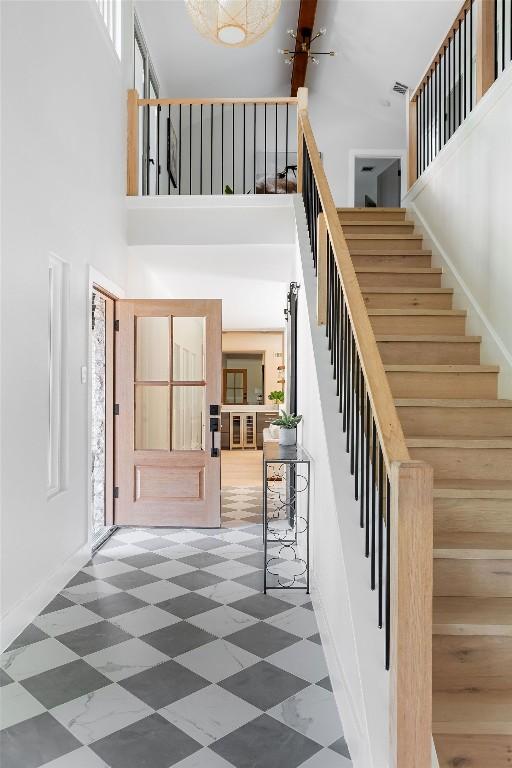 7302 Jester Blvd, Austin, TX 78750 - entrance foyer with a towering ceiling, tile patterned floors, stairs, and baseboards