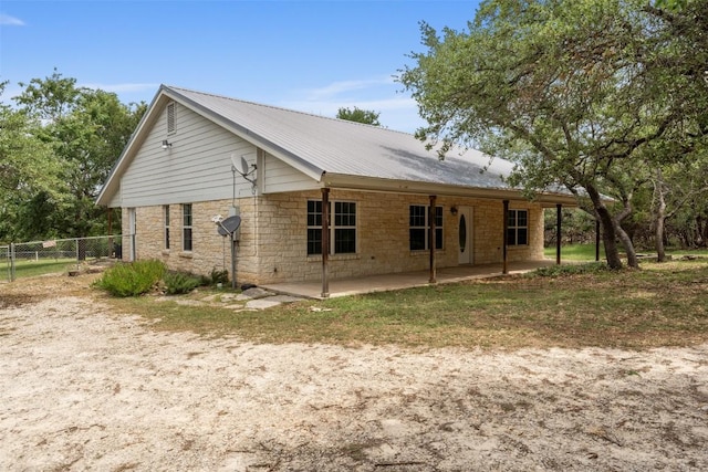 8281 Mountain Dr, Salado, TX 76571 - view of property exterior with a patio area, metal roof, and stone siding
