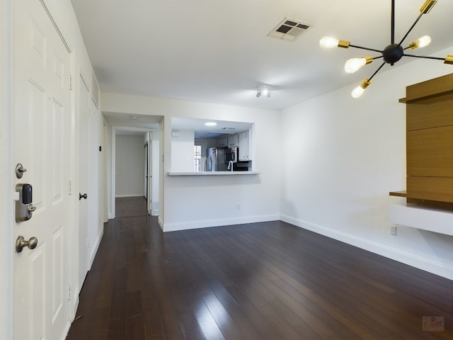 2104 Cullen Ave Unit 117, Austin, TX 78757 - unfurnished living room featuring baseboards, dark wood finished floors, and a chandelier
