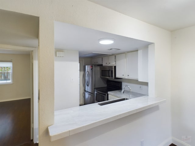 2104 Cullen Ave Unit 117, Austin, TX 78757 - kitchen featuring appliances with stainless steel finishes, light countertops, a sink, and baseboards