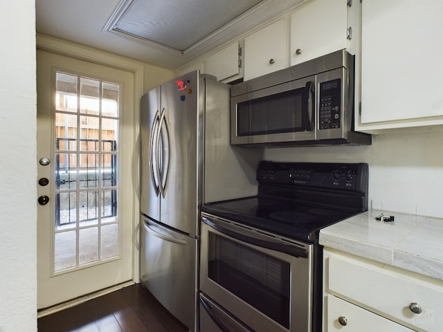 2104 Cullen Ave Unit 117, Austin, TX 78757 - kitchen with stainless steel appliances, white cabinets, tile counters, and dark wood-style flooring