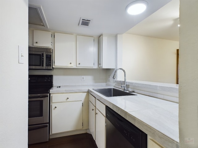 2104 Cullen Ave Unit 117, Austin, TX 78757 - kitchen with stainless steel appliances, a sink, light countertops, and white cabinetry