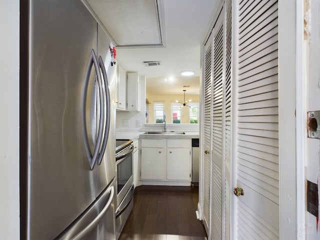 2104 Cullen Ave Unit 117, Austin, TX 78757 - kitchen featuring stainless steel appliances, a sink, light countertops, white cabinets, and dark wood-style floors
