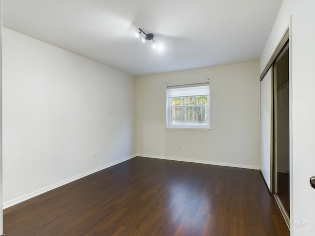 2104 Cullen Ave Unit 117, Austin, TX 78757 - unfurnished bedroom with dark wood-style floors, a closet, and baseboards