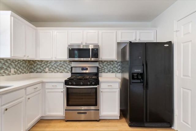 1025 Doras Dr, Pflugerville, TX 78660 - kitchen with appliances with stainless steel finishes, white cabinetry, light countertops, and decorative backsplash