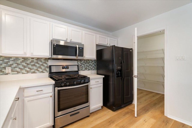 1025 Doras Dr, Pflugerville, TX 78660 - kitchen featuring appliances with stainless steel finishes, white cabinetry, light wood-style floors, and backsplash