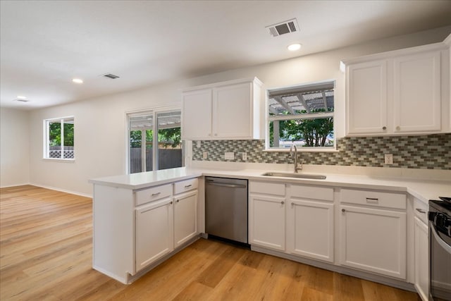 1025 Doras Dr, Pflugerville, TX 78660 - kitchen featuring stainless steel appliances, a peninsula, white cabinetry, tasteful backsplash, and recessed lighting