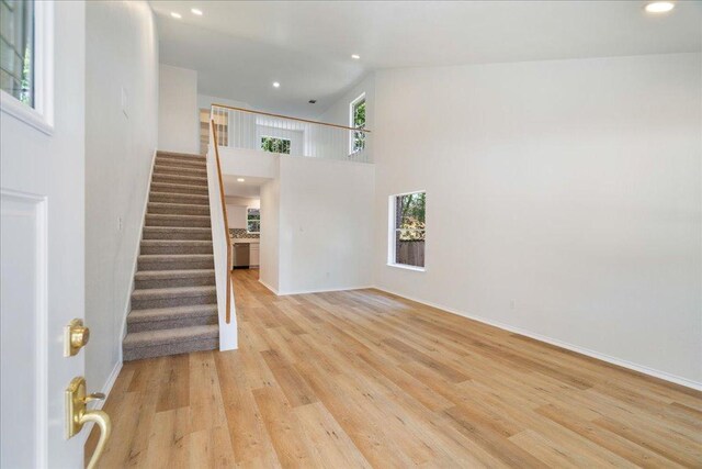 1025 Doras Dr, Pflugerville, TX 78660 - unfurnished living room with stairs, recessed lighting, and light wood-style floors