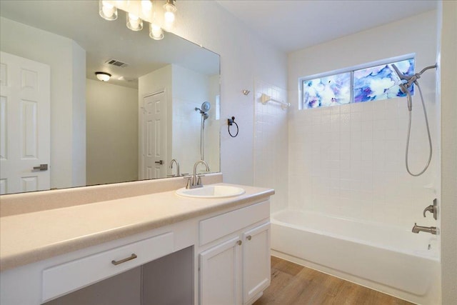 1025 Doras Dr, Pflugerville, TX 78660 - bathroom with washtub / shower combination, vanity, and wood finished floors