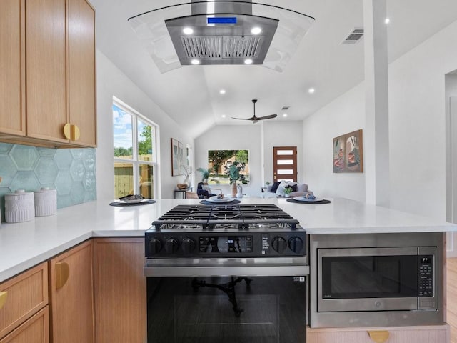 2401 Lendall Ln, Austin, TX 78744 - kitchen with range with gas stovetop, stainless steel microwave, wall chimney exhaust hood, a peninsula, and light countertops