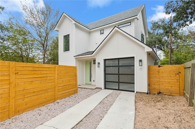 3321 Hemlock Ave Unit 2, Austin, TX 78722 - modern farmhouse style home featuring roof with shingles, concrete driveway, a fenced backyard, an attached garage, and board and batten siding