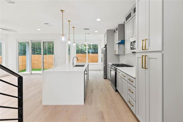 3321 Hemlock Ave Unit 2, Austin, TX 78722 - kitchen with stainless steel appliances, light countertops, light wood-type flooring, decorative light fixtures, and recessed lighting