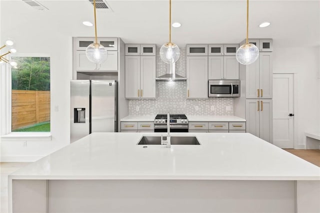 3321 Hemlock Ave Unit 2, Austin, TX 78722 - kitchen with appliances with stainless steel finishes, tasteful backsplash, a center island with sink, light countertops, and recessed lighting