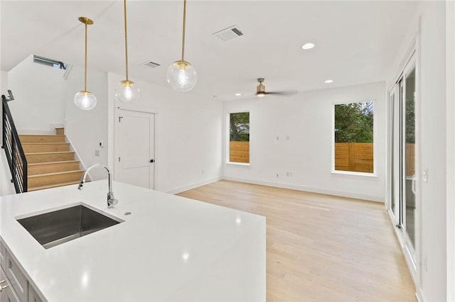 3321 Hemlock Ave Unit 2, Austin, TX 78722 - kitchen with light wood-style floors, a ceiling fan, light countertops, decorative light fixtures, and recessed lighting